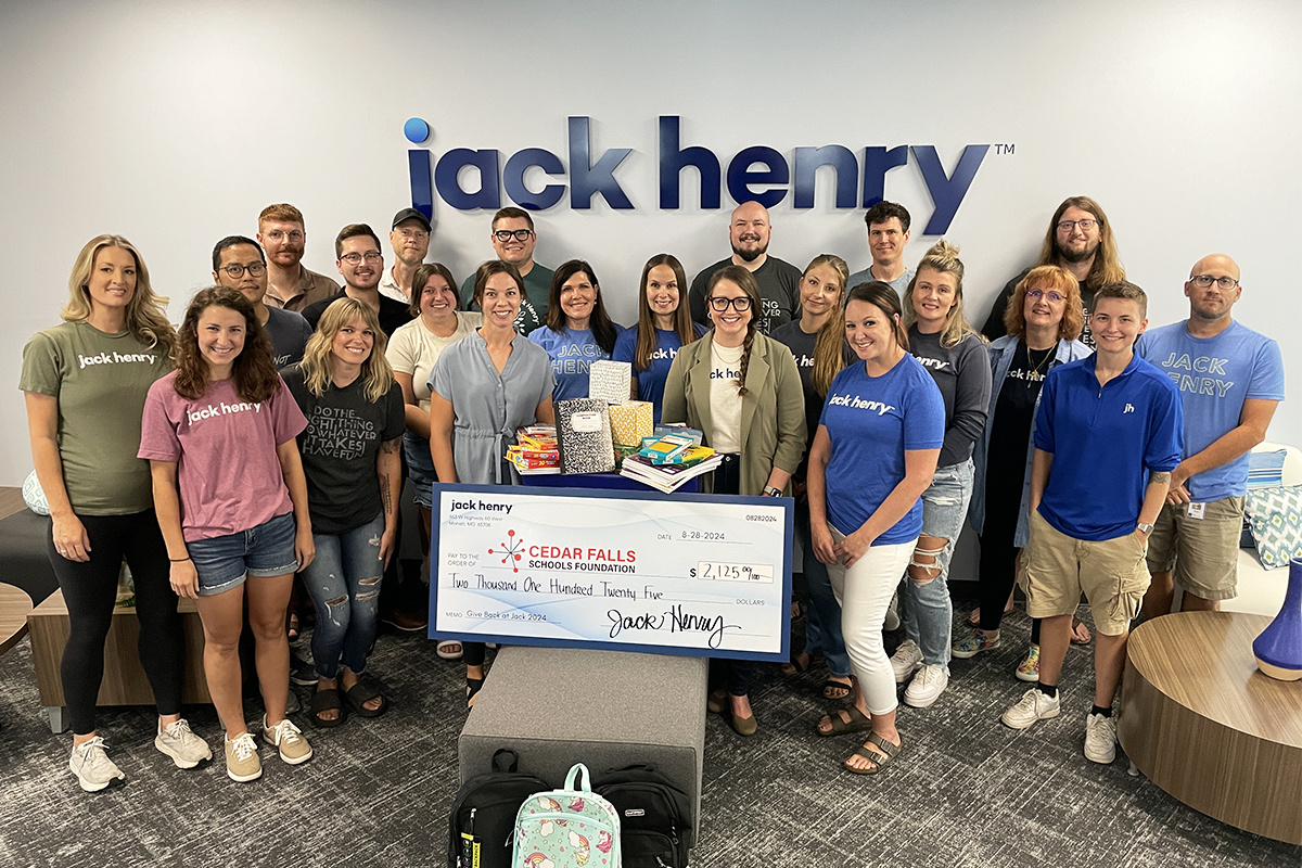 Jack Henry associates posed for a photo alongside donated school supplies and hygiene items image